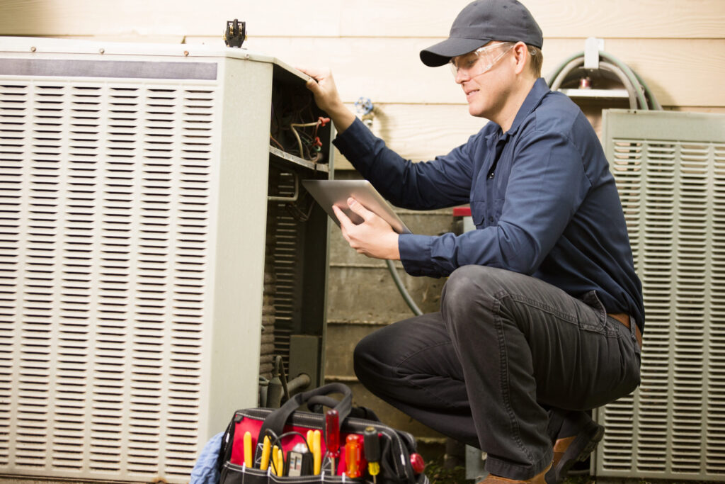 Air conditioner repairman works on home unit. Blue collar worker. HVAC service Chicago